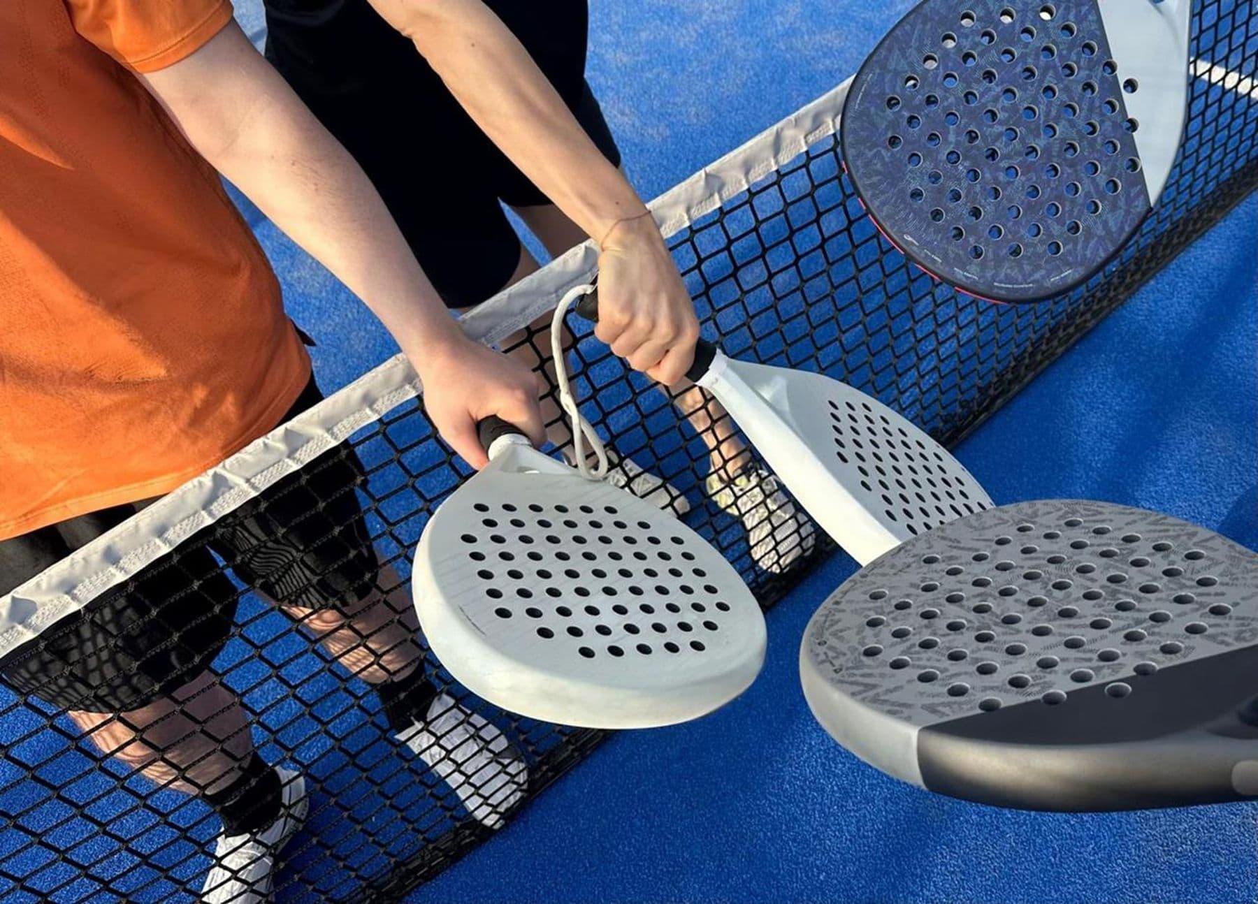 Players tapping rackets over the net before a match